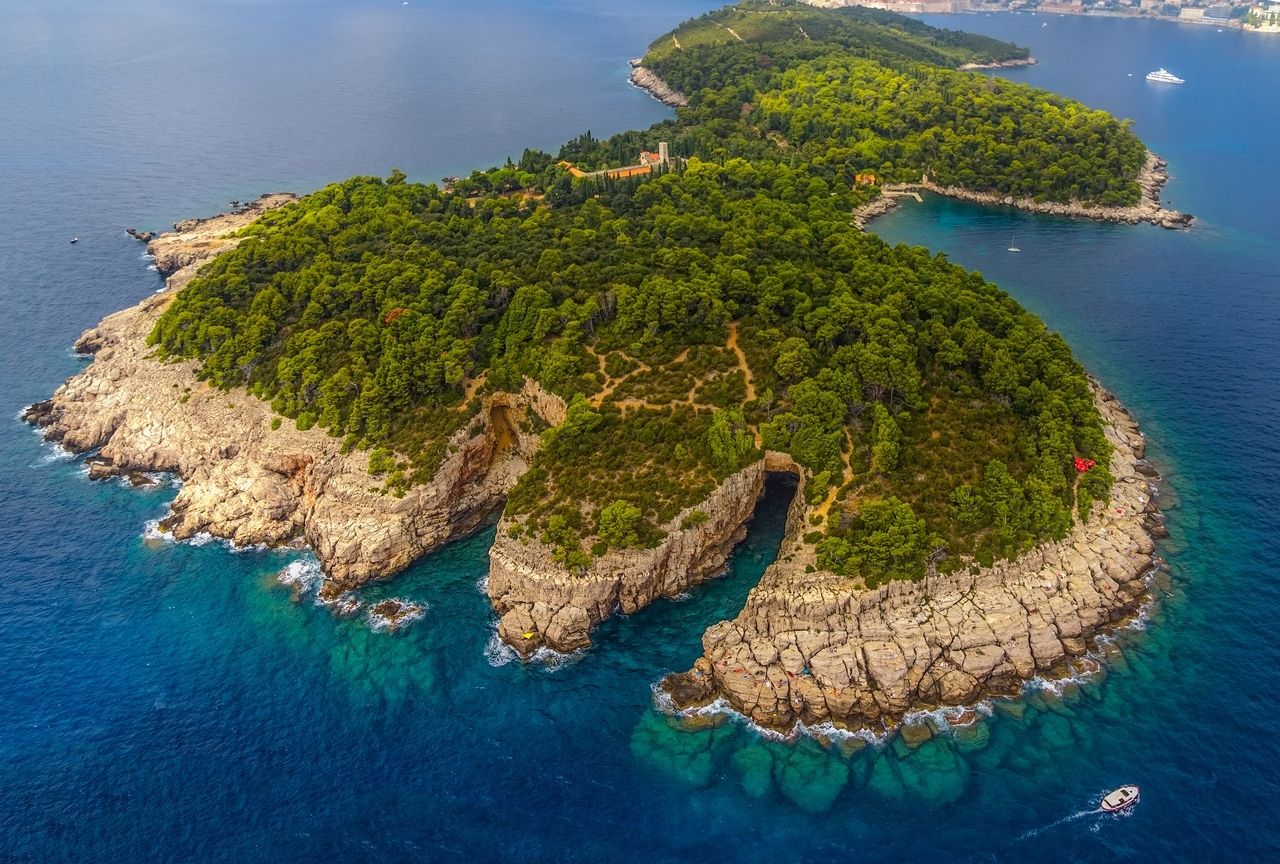 Vedere aeriană a insulei Lokrum din fața Dubrovnikului, înconjurată de apă limpede și albastră